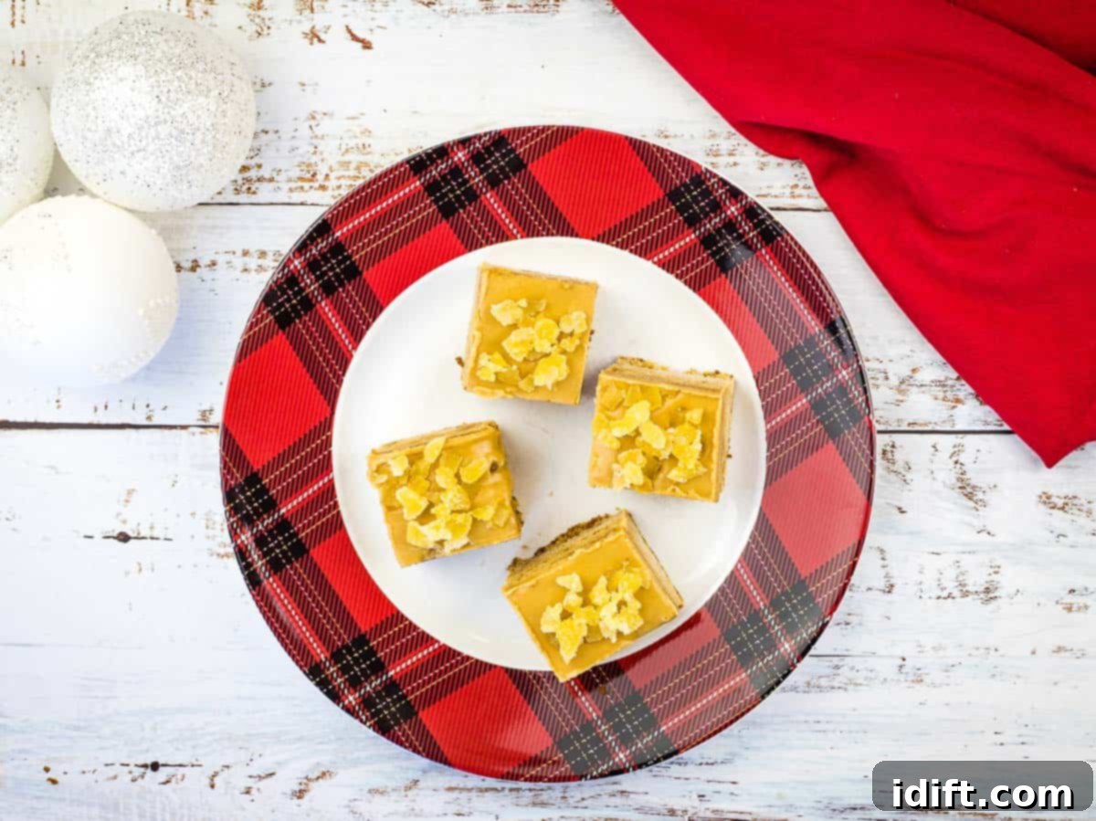 A charming plate holding four square slices of triple ginger cake bars, showcasing their moist texture.