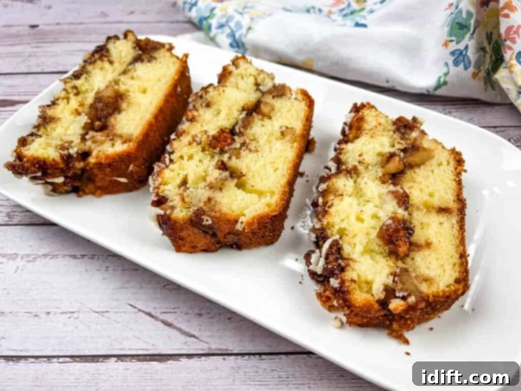 Three perfectly sliced pieces of tender banana bread artfully arranged on a pristine white plate, ready to be enjoyed.