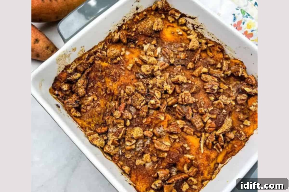 A golden-brown Sweet Potato Casserole with a toasted marshmallow or pecan topping in a baking dish.