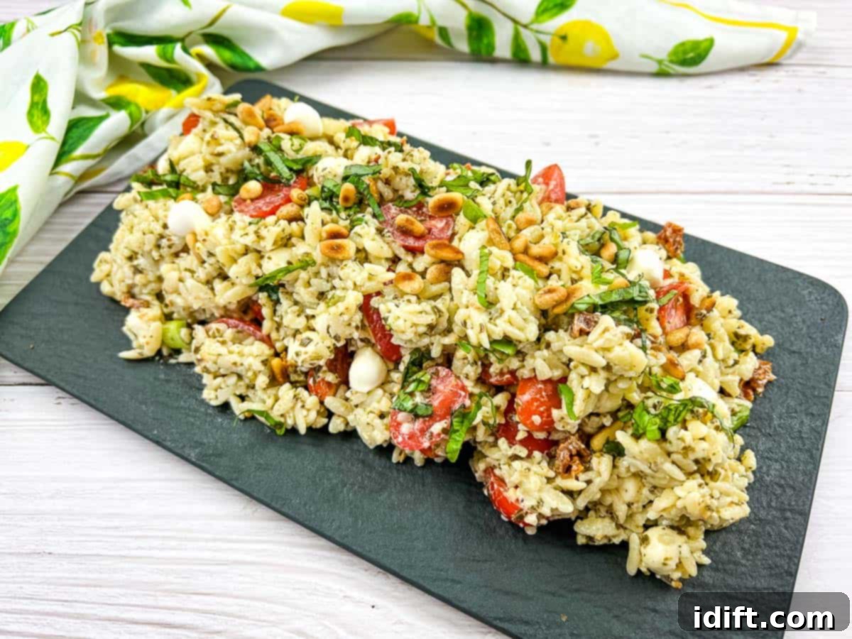 Orzo salad resting on a dark plate.