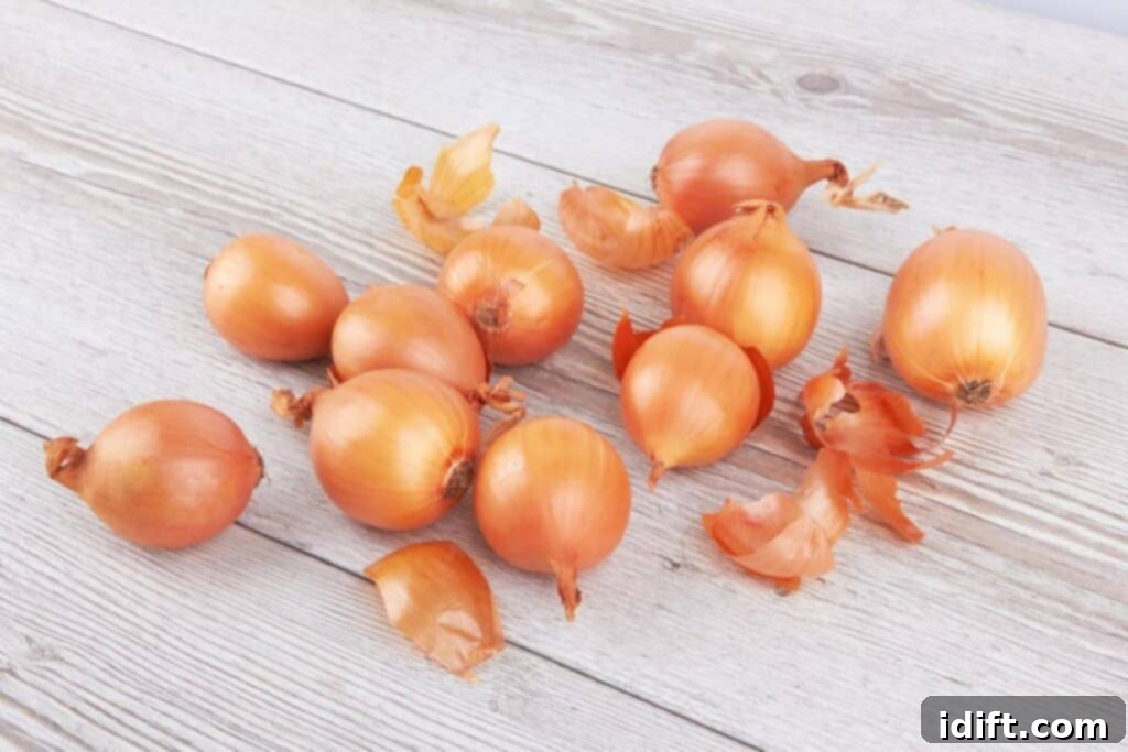 Keep Onions Fresh Longer 5 A group of whole yellow onions with papery skins neatly arranged on a rustic wooden surface, signifying proper storage.