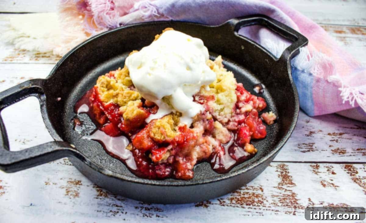 15 Vibrant Spring Dishes That Will Entice You to Dine Al Fresco 4 Strawberry Rhubarb Crumble in cast iron with vanilla ice cream on top.