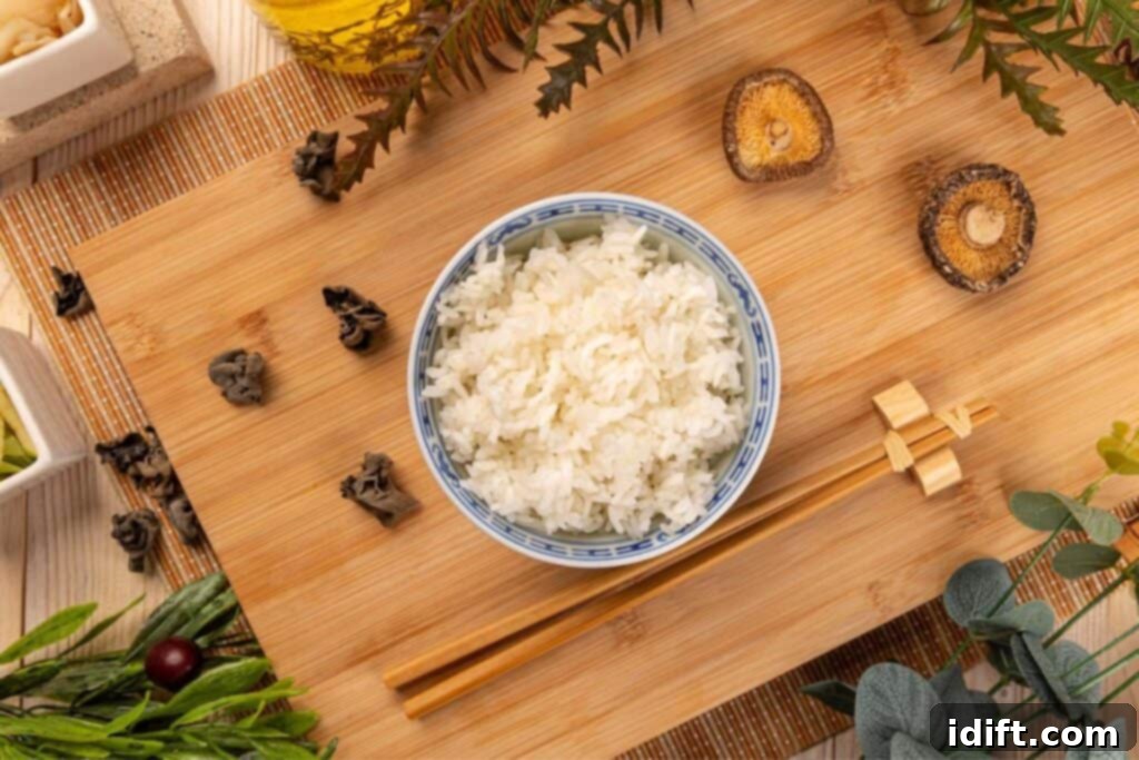 Cook Basmati Like A Chef Achieve Fluffy Perfection 3 A bowl of steamed rice on a bamboo mat surrounded by asian-inspired decor.