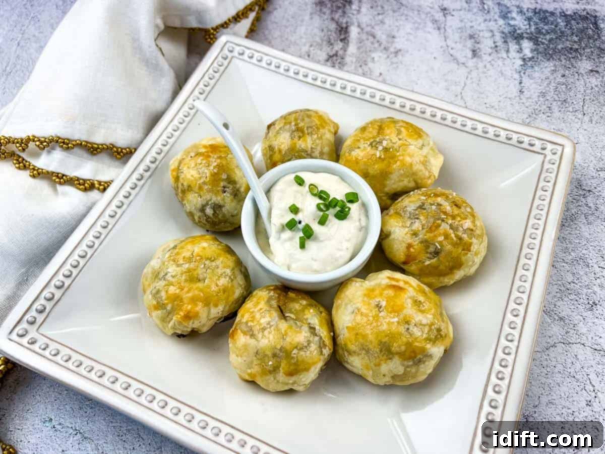 Light and Flavorful Spring Appetizers for Effortless Entertaining 3 Beef Wellington Bites on a white plate with sauce in the middle.