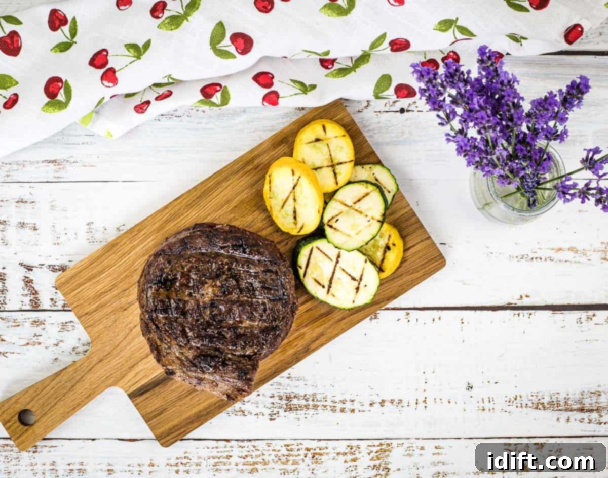 13 Meals Transformed by the Grill 5 A top-down shot of Grilled Ribeye Cap Steak on a cutting board with veggies.