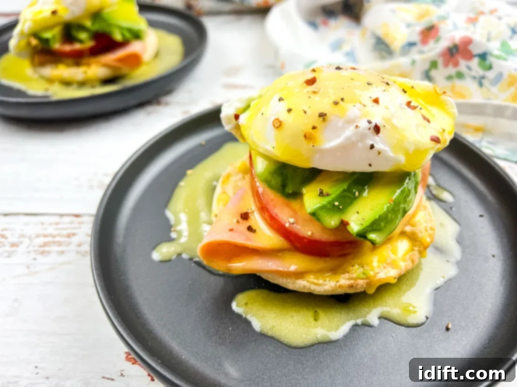 15 Breakfasts With Zero Dish Cleanup 2 Eggs benedict with ham and avocado on an English muffin served on a black plate.