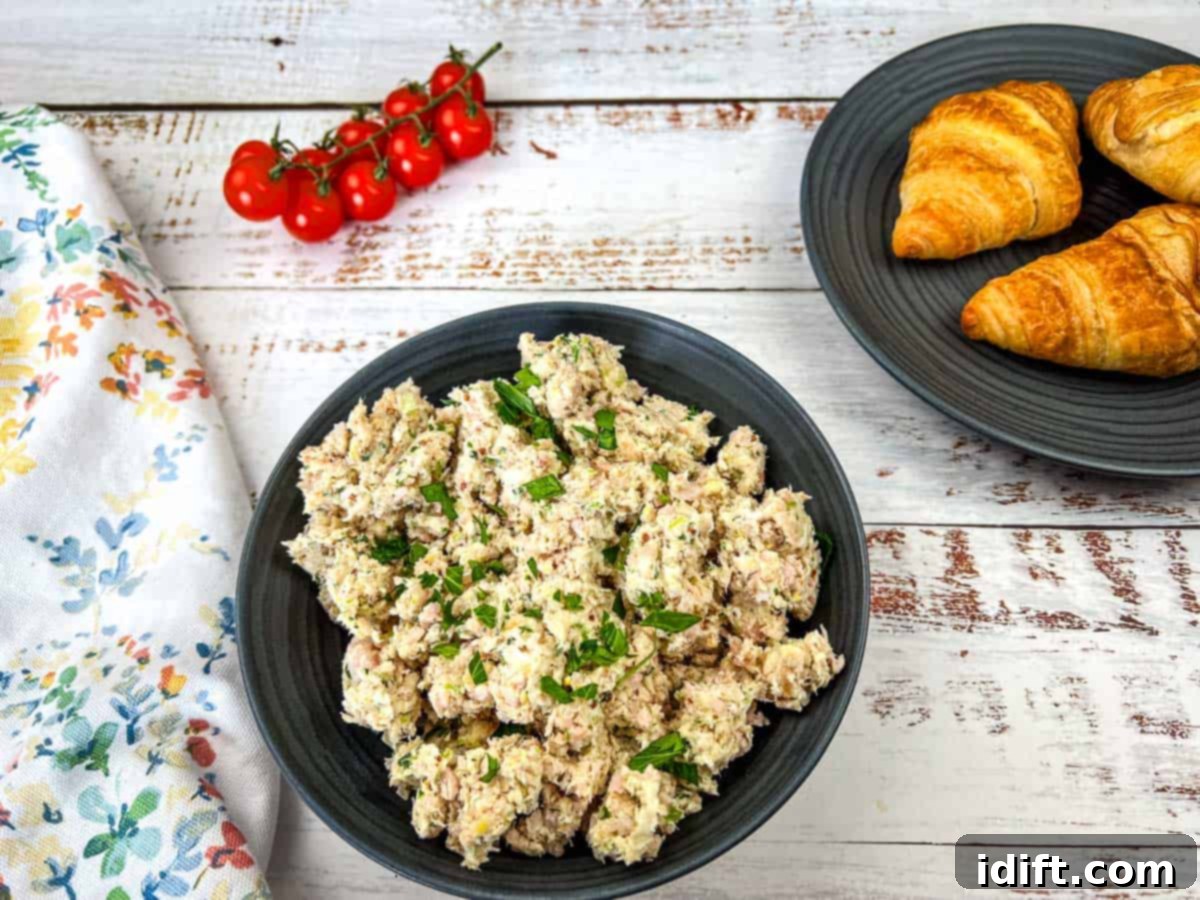 A bowl of Southern ham salad and croissants on a wooden table.