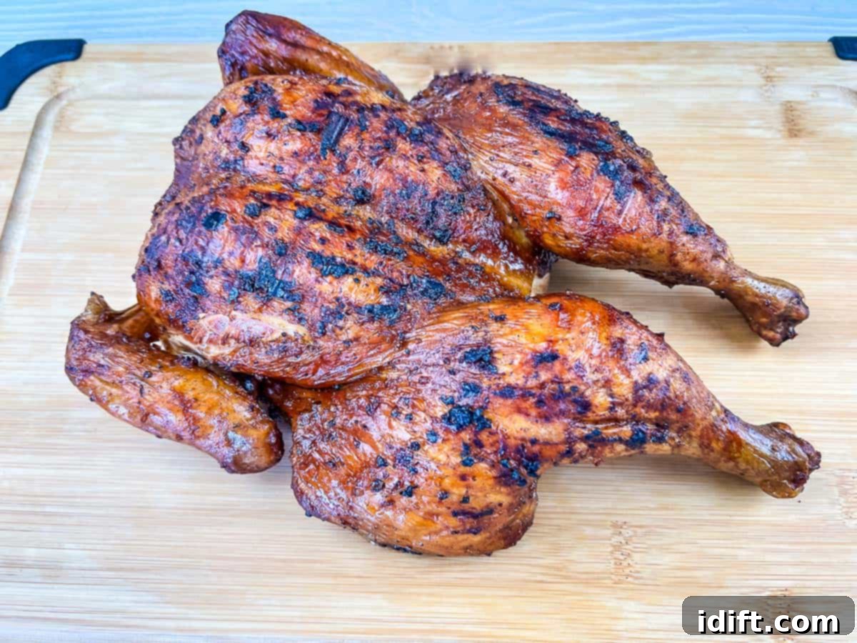 Taste The Heat: 17 Grilling Recipes To Ignite Your Weekend 2 A beautifully smoked whole chicken, perfectly grilled with crispy skin, presented on a wooden cutting board.