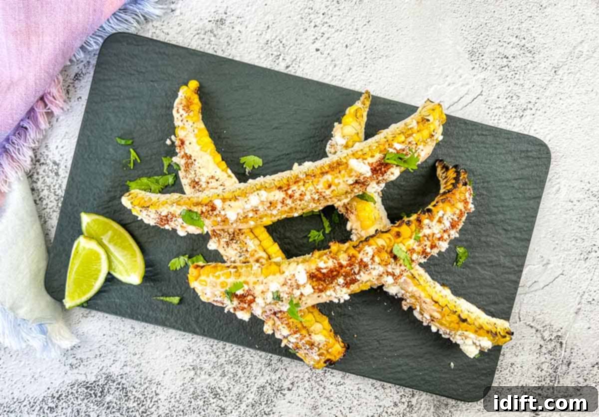 Grilled Elote Corn Ribs on a black platter, garnished with cilantro and lime.