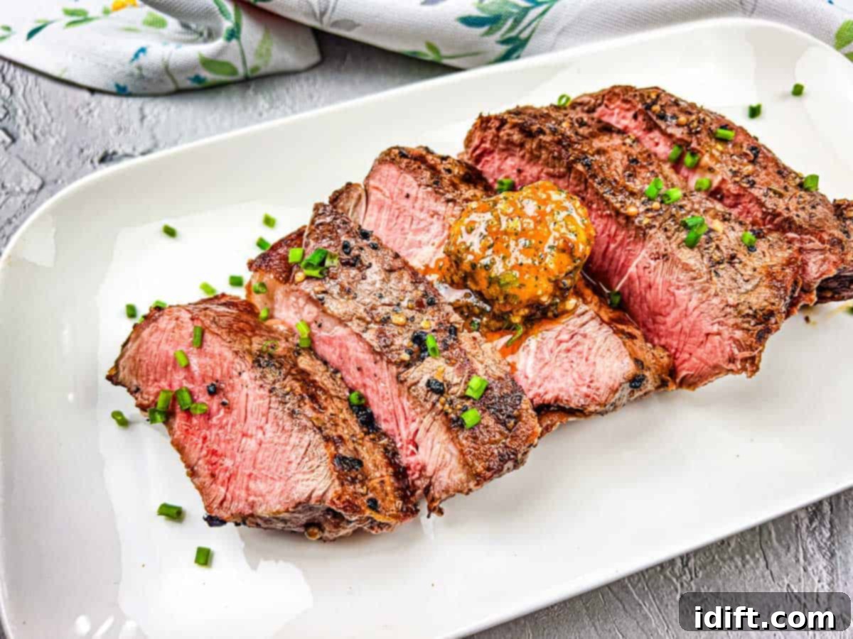 15 Grilled Meats Your Taste Buds Will Thank You For 11 A grilled steak with cowboy butter on a white plate.