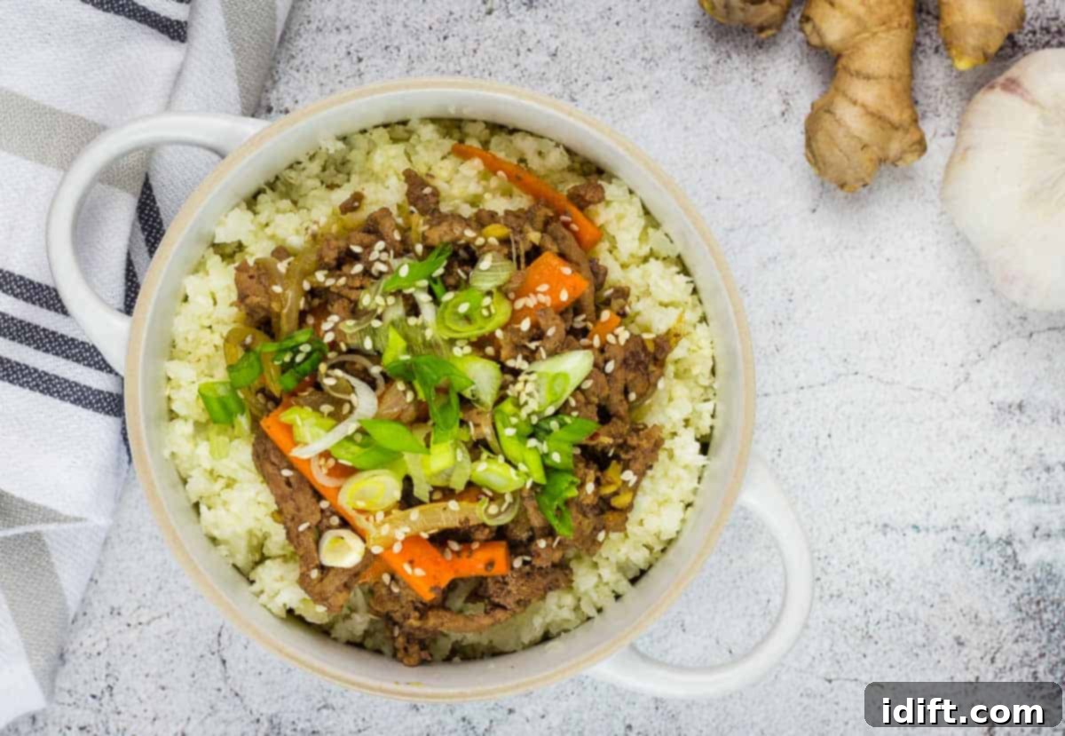 17 Ground Beef Recipes Too Good For Cookbooks 6 Overhead shot of a vibrant Korean Beef Bowl, garnished with sesame seeds and green onions, with chopsticks.