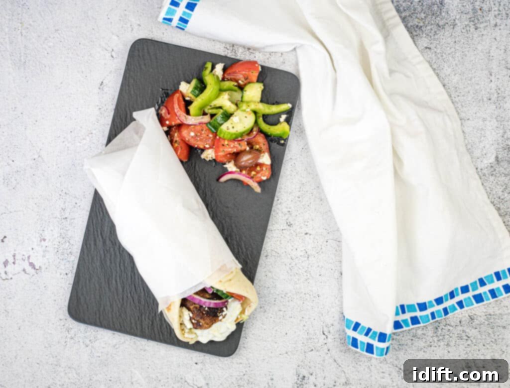 Mediterranean Meatball Pita Pockets 12 Top-down shot of a Greek Meatball Pita Sandwich on a black slate plate, featuring all the delicious layers.