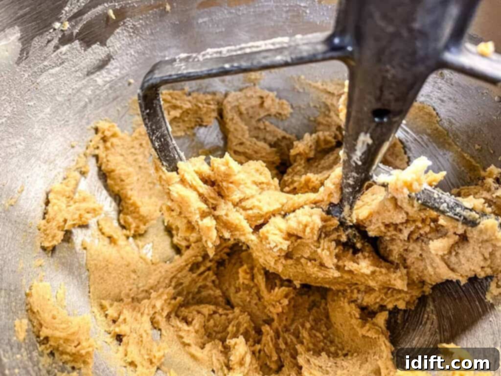 A bowl containing dry ingredients: flour, pumpkin pie spice, cinnamon, and baking soda, being whisked together.