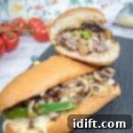 Elevated Ground Beef Philly Cheesesteak 11 Halves of Ground Beef Philly Cheesesteak on a slate plate.