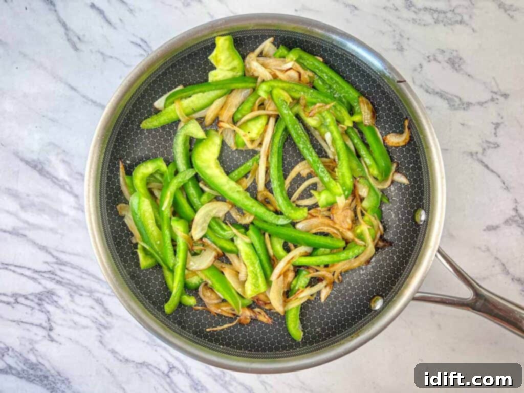 Elevated Ground Beef Philly Cheesesteak 7 Sauté onions until caramelized, then add green bell pepper.