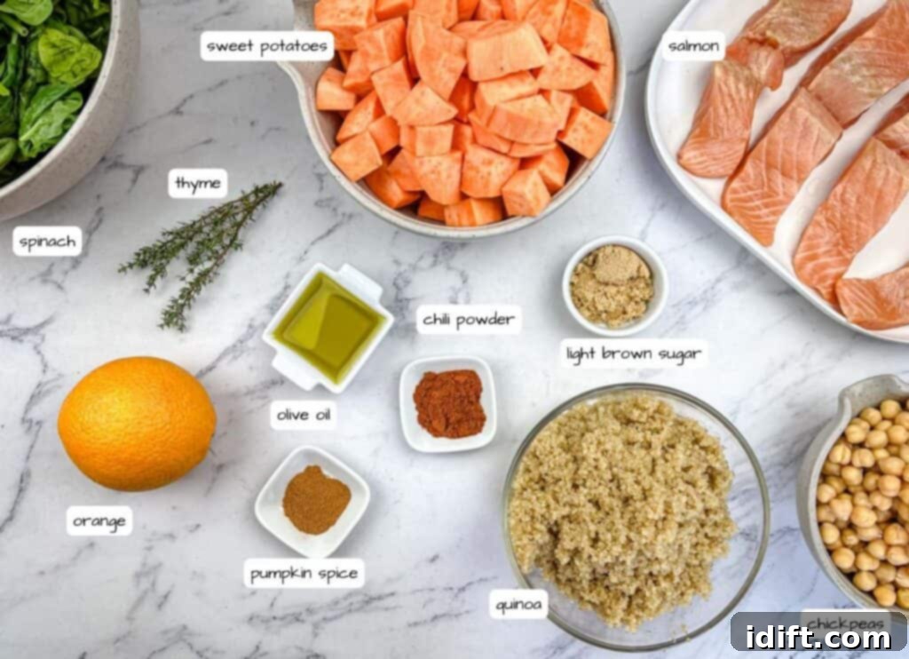 Golden Autumn Salmon Bowl 4 Individual ingredients for the salmon bowl laid out on a clean surface, clearly labeled for easy identification. This includes sweet potatoes, olive oil, chili powder, orange, salt, brown sugar, pumpkin spice, thyme, salmon, pepper, quinoa, spinach, and chickpeas.