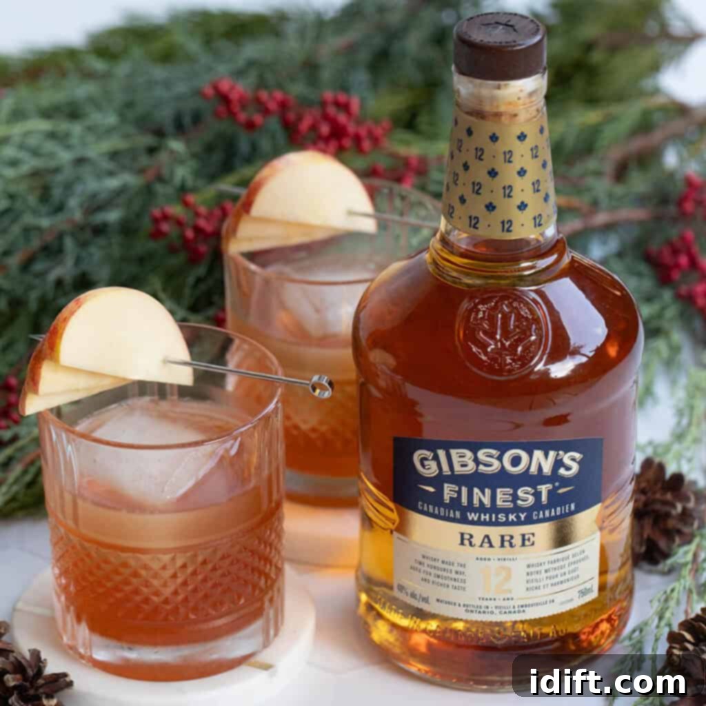 Homestyle Apple Pie Old Fashioned 5 A bottle of Gibson's whisky with two glasses and apple on top.