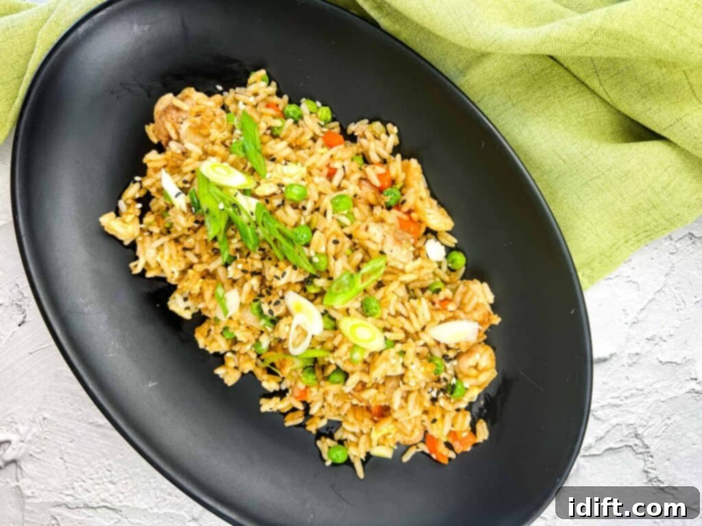 Anatolian Fried Rice 3 Top-down shot of Turkey Fried Rice sizzling on a Blackstone Griddle, ready to be served on a black plate.