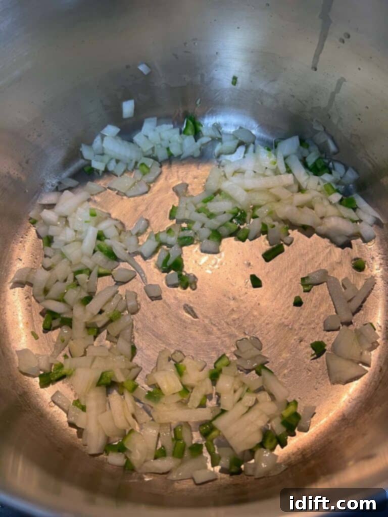 Southwestern Turkey Tortilla Soup 6 Onions and jalapeno cooking in a pot.