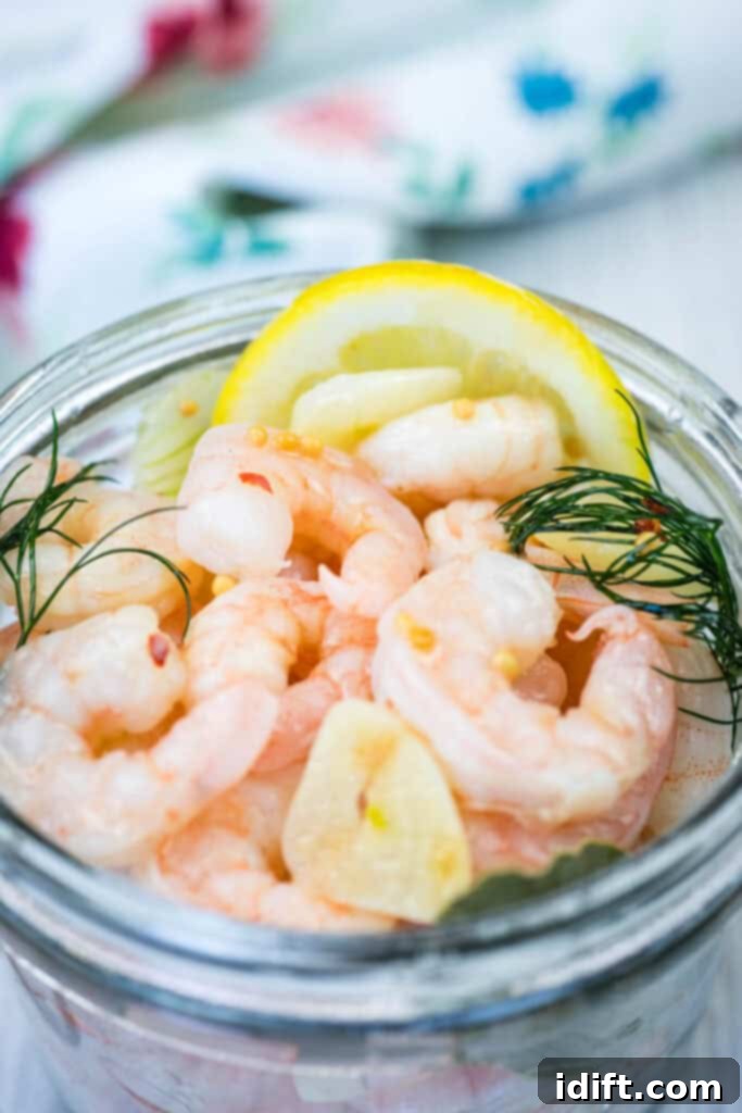 A jar with a pickled shrimp, garnished with dill and lemon slices.