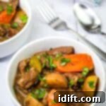 A bowl of Classic beef stew beside the spoon and fork.
