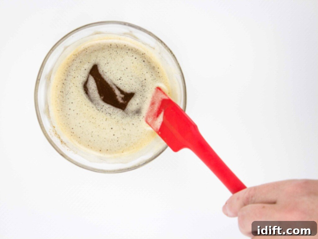 Brown butter in a small glass dish with a red spatula.
