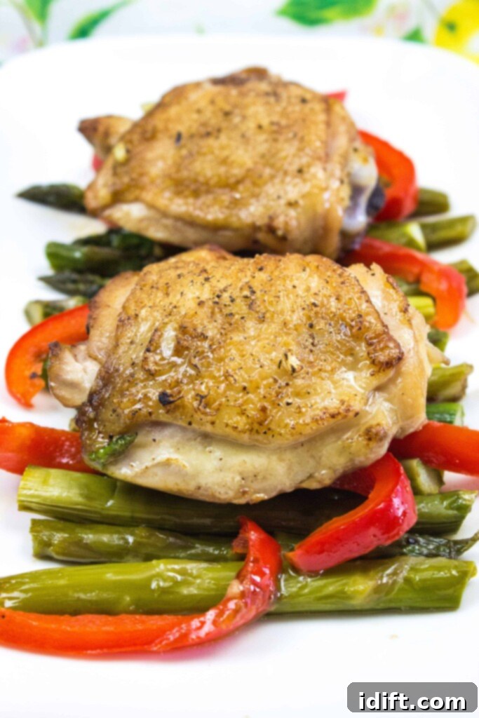 Roasted Garlic Chicken and Asparagus 3 A generous serving of garlic chicken with tender-crisp asparagus in a white oval platter, perfect for sharing.