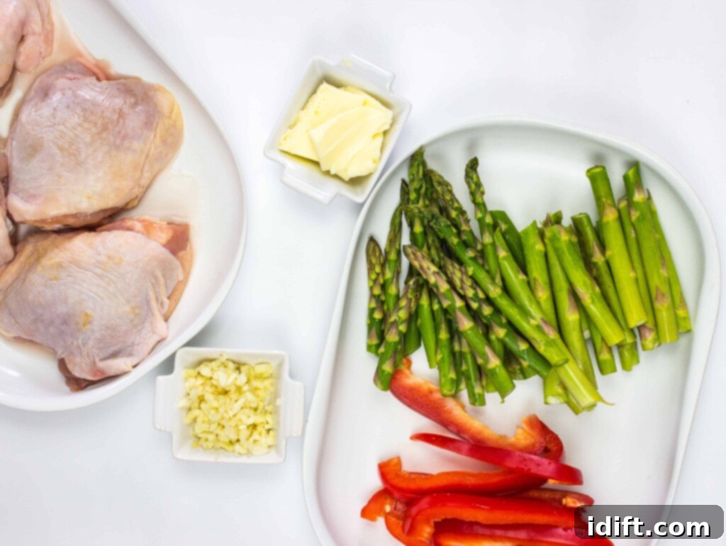 Roasted Garlic Chicken and Asparagus 5 A close-up of chopped red bell pepper, trimmed asparagus spears, and minced garlic on a cutting board, demonstrating ingredient preparation.