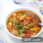 Unstuffed Cabbage Soup 11 A spoon getting small amount of Cabbage roll soup in a white bowl.