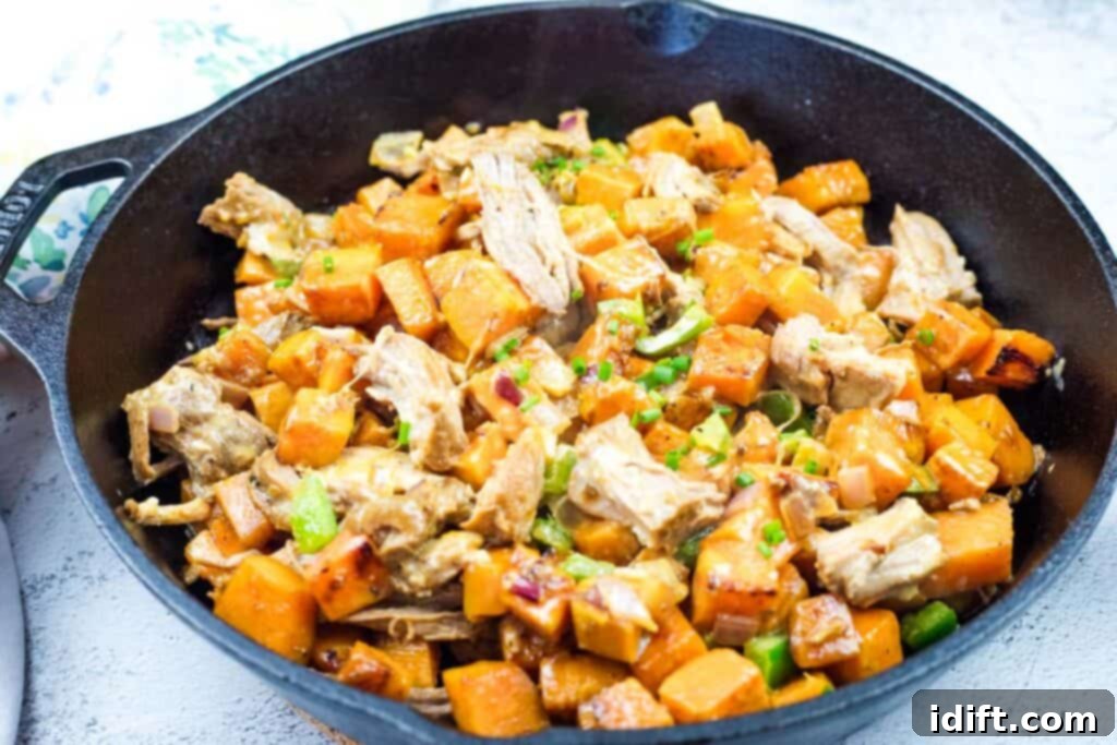 Sweet Potato Hash with Pulled Pork & Chipotle Butter on a skillet.