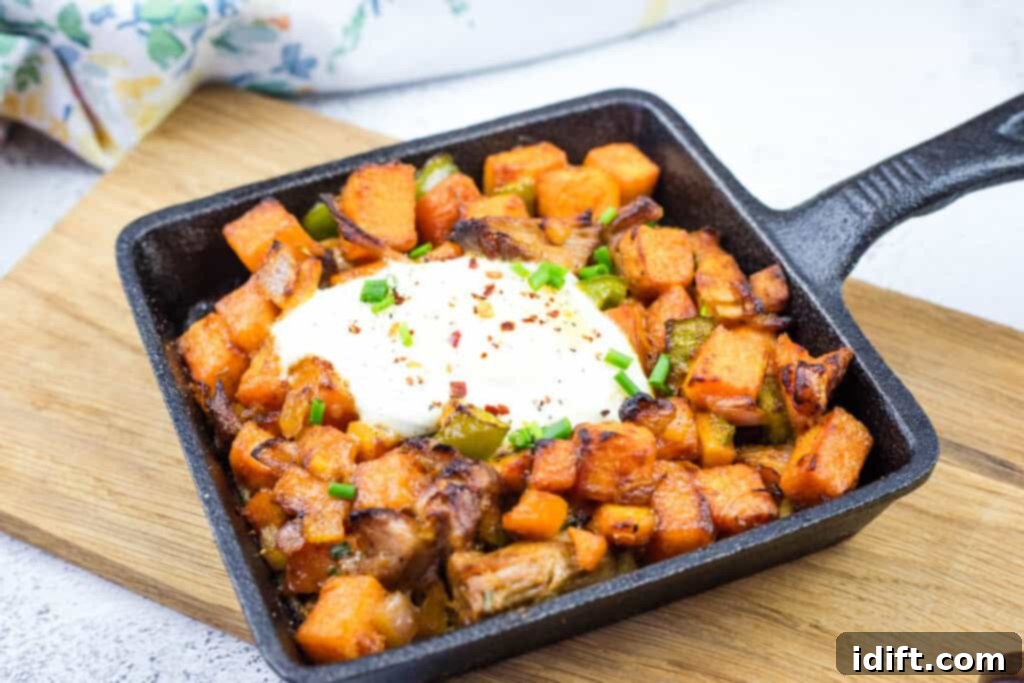 A skillet of Sweet Potato Hash and Pulled Pork with heavy cream on top.