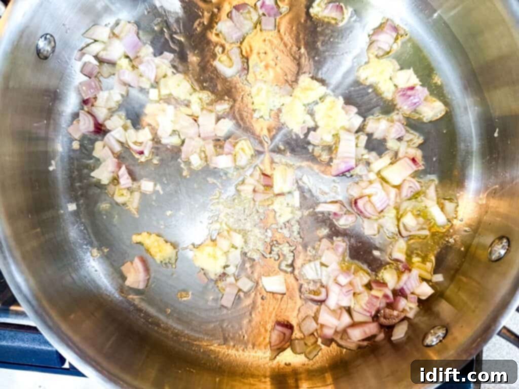 Cloud-Like Ricotta Meatballs with Rich Tomato Sauce 11 Finely chopped shallots being sautéed in shimmering olive oil in a pan, creating a fragrant base for the sauce.