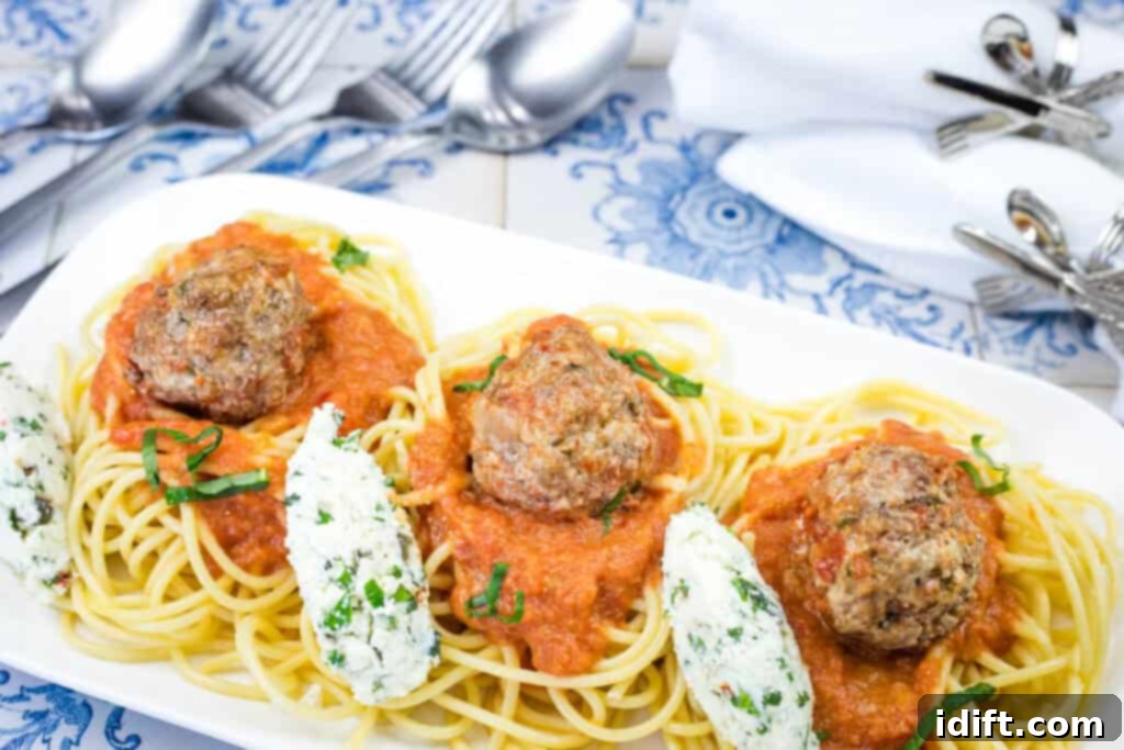 Cloud-Like Ricotta Meatballs with Rich Tomato Sauce 13 A beautifully plated dish of spaghetti with ricotta meatballs and tomato sauce, garnished with fresh basil, on a white plate.