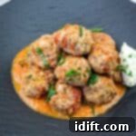 Cloud-Like Ricotta Meatballs with Rich Tomato Sauce 15 A serving of Ricotta Meatballs with Tomato Sauce on a black plate.