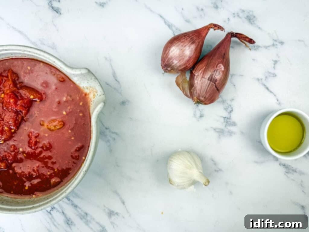 Cloud-Like Ricotta Meatballs with Rich Tomato Sauce 10 Key ingredients for the tomato sauce, including olive oil, shallots, and crushed tomatoes, elegantly presented on a table.