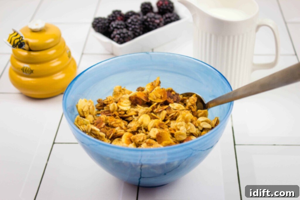 A vibrant blue bowl filled with golden honey almond granola, garnished with fresh berries and a spoon, set against a warm, inviting background, perfect for a healthy breakfast.
