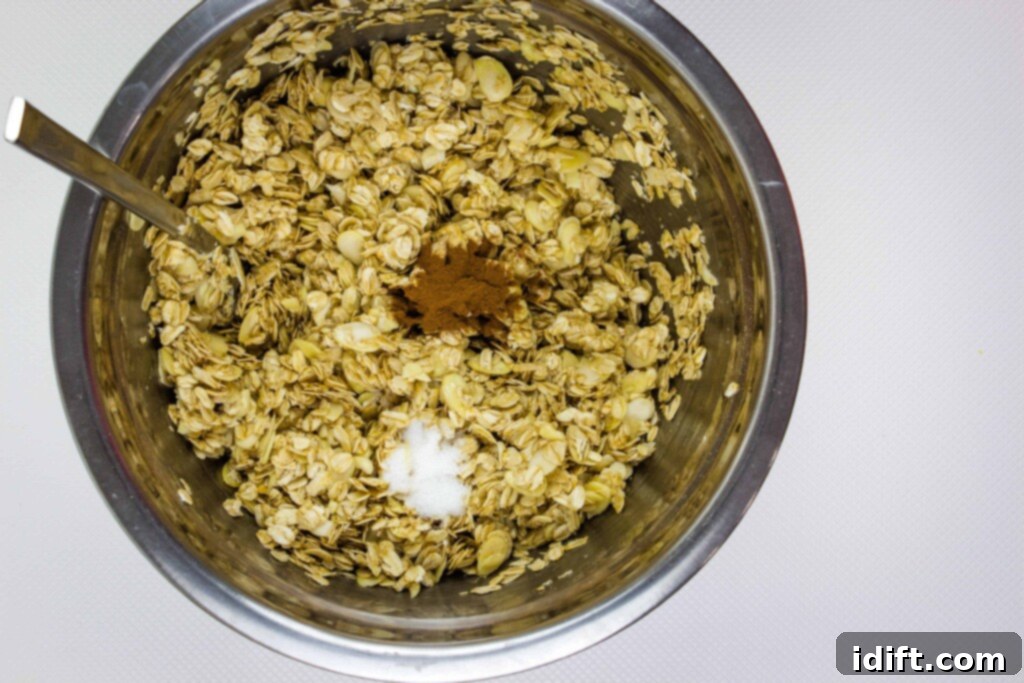 A step-by-step image depicting the process of adding ground cinnamon and salt to a bowl of oats and almonds, followed by drizzling the golden mixture of oil and honey over the ingredients for honey almond granola.