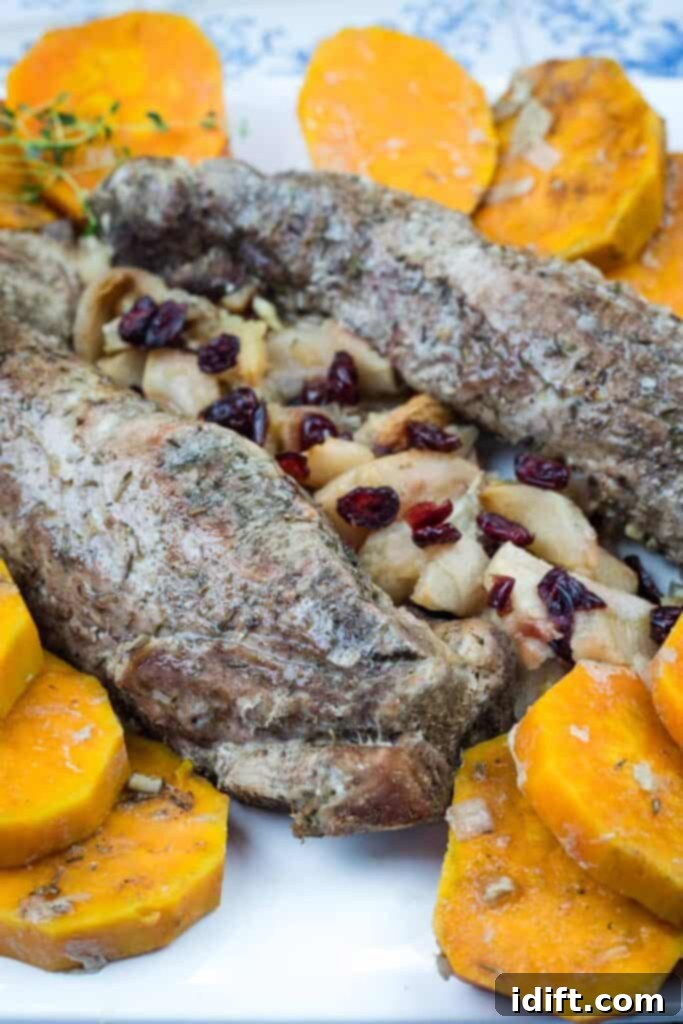 A serving of Slow Cooker Pork Tenderloin with Sweet Potatoes & Apples, garnished and ready to enjoy.