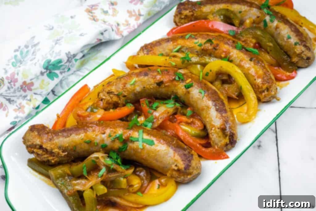 Plate of grilled Italian sausages served with sautéed red, yellow, and green bell peppers, garnished with fresh chopped herbs for a vibrant presentation.