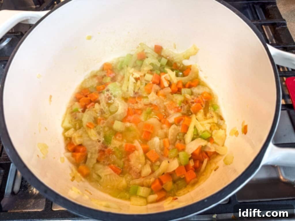 Deglazing the vegetables with the white wine in a pot.