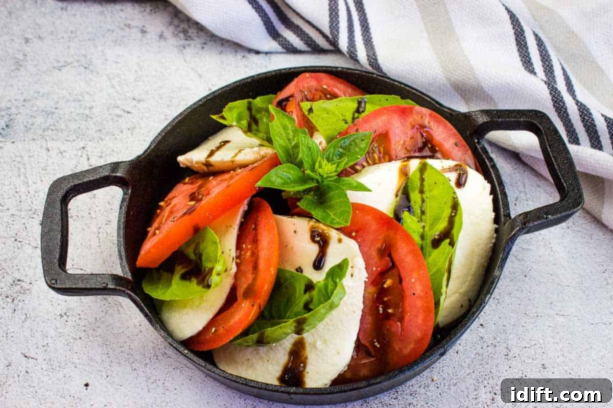 17 Effortless Sides That Prove Dinner Doesn't Have To Be Hard 14 A top-down shot of a classic caprese salad in a black dish.