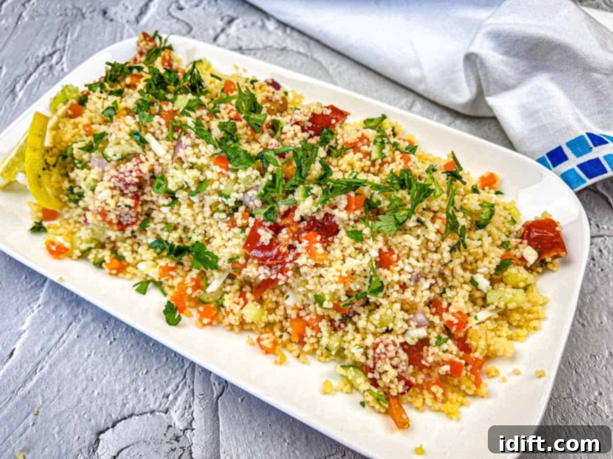 17 Effortless Sides That Prove Dinner Doesn't Have To Be Hard 18 A plate of Mediterranean Couscous Salad With Smoked Tomatoes topped with parsley.