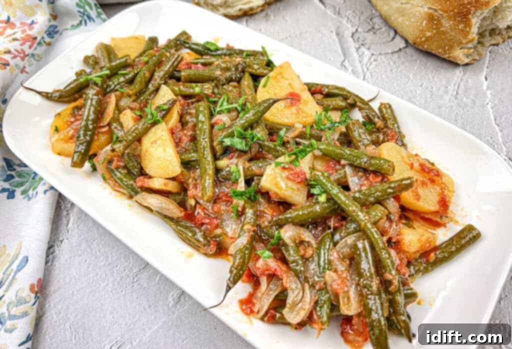 17 Effortless Sides That Prove Dinner Doesn't Have To Be Hard 3 Greek Green Beans served on a white rectangular plate.