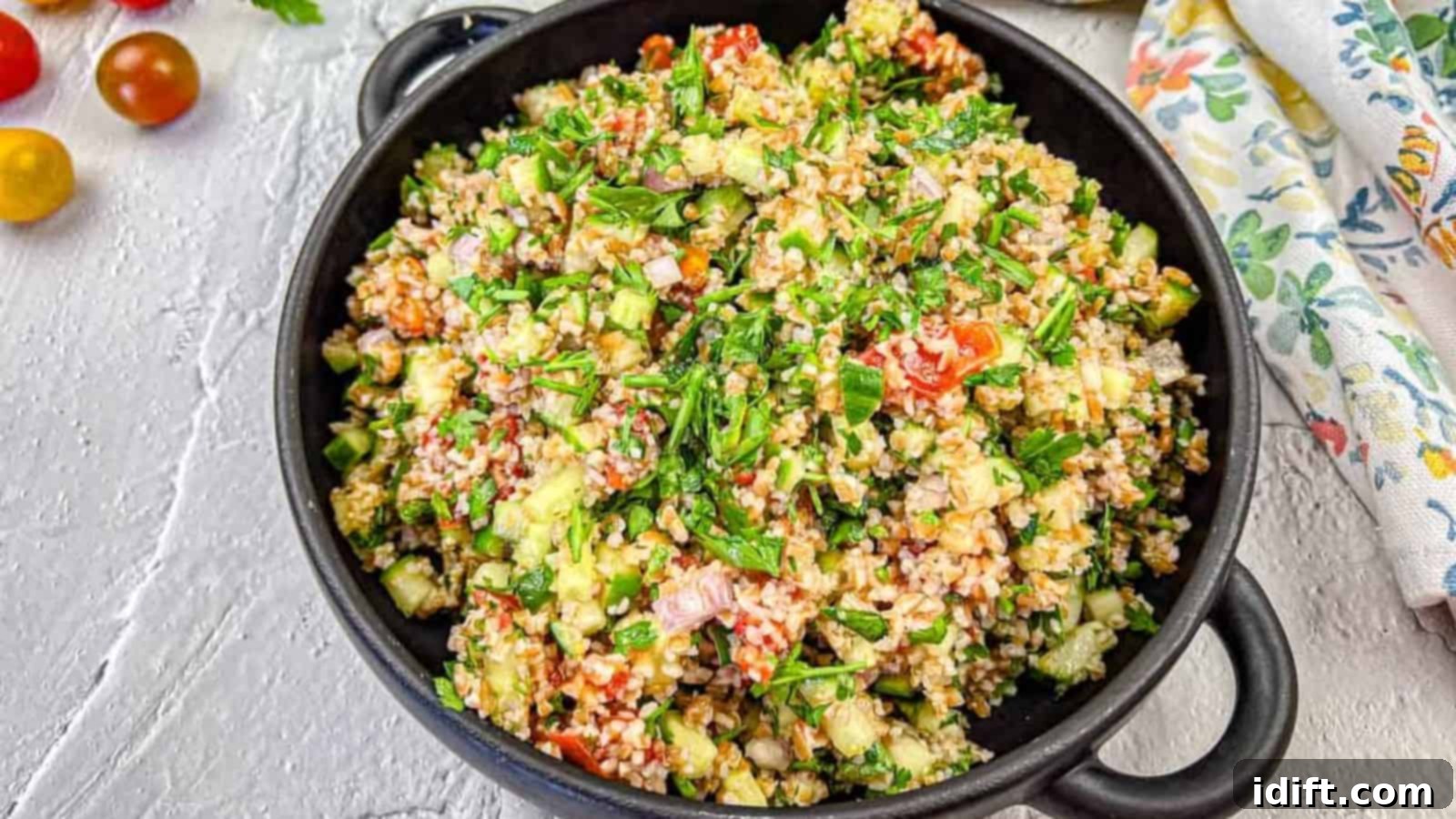 17 Effortless Sides That Prove Dinner Doesn't Have To Be Hard 9 A black bowl filled with tabbouleh salad with smoked tomatoes.