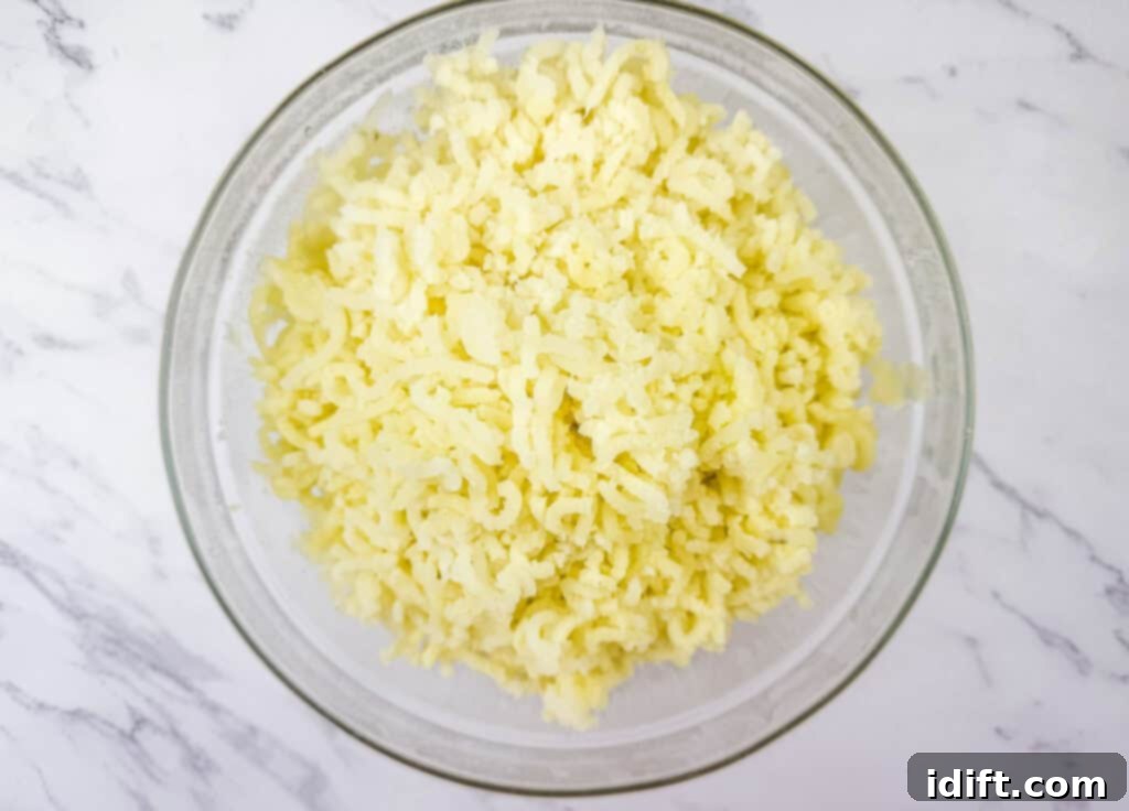 Glass bowl filled with freshly riced potatoes, creating a light and fluffy texture.