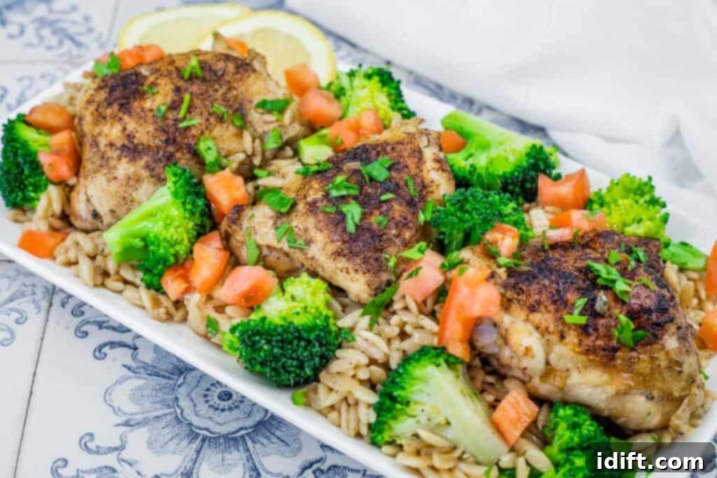 A plate of Lemon Chicken Orzo Skillet with Broccoli, featuring tender chicken, orzo, and broccoli, garnished with fresh herbs and lemon wedges, ready to be served and enjoyed.
