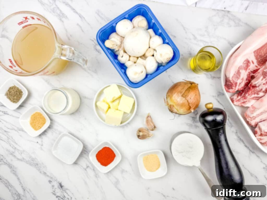 Ingredients for Smothered Pork Chops with Onions & Mushrooms on a marble countertop including mushrooms, pork, broth, onion, butter, cream, olive oil, spices, flour, garlic, pepper grinder, and measuring cup.