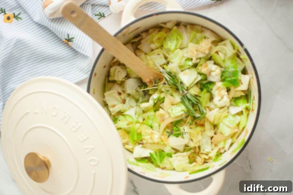 A clean white pot holds a mixture of chopped cabbage, aromatic herbs, and crushed garlic, all resting on a striped linen cloth, hinting at the next stage of flavor development.