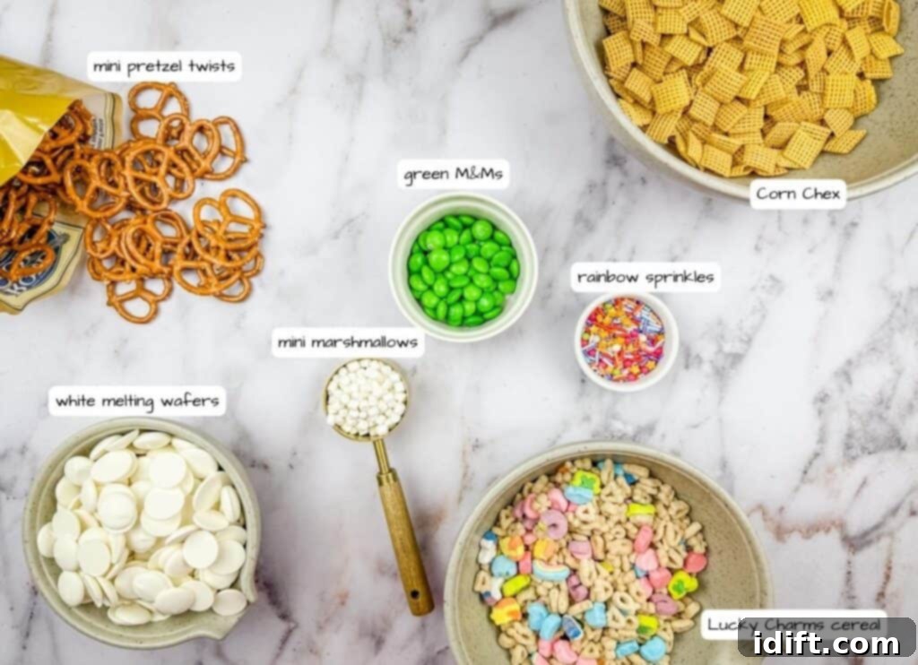 Emerald Enticement 4 Various snack ingredients are arranged on a table, including mini pretzel twists, Corn Chex, Lucky Charms cereal, white melting wafers, mini marshmallows, green M&Ms, and rainbow sprinkles.