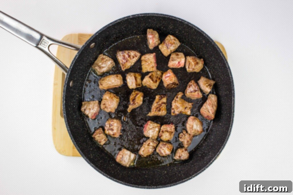 Hearty Hungarian Goulash 5 Close-up of seasoned beef chunks browning in a hot skillet, developing a rich, golden crust.